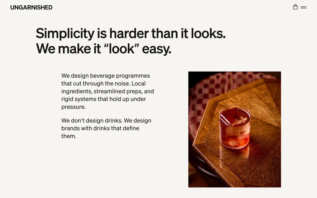 Screenshot of the UNGARNISHED consultancy webpage featuring the headline “Simplicity is harder than it looks”, accompanying copy about beverage programme design, and a photograph of a cocktail on a wooden table.