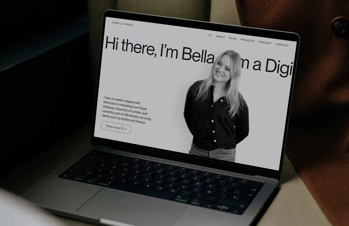 Laptop displaying Isabella Vranic’s portfolio homepage with bold typography reading 'Hi there, I'm Bella...', a portrait photo, bio text, and navigation links.