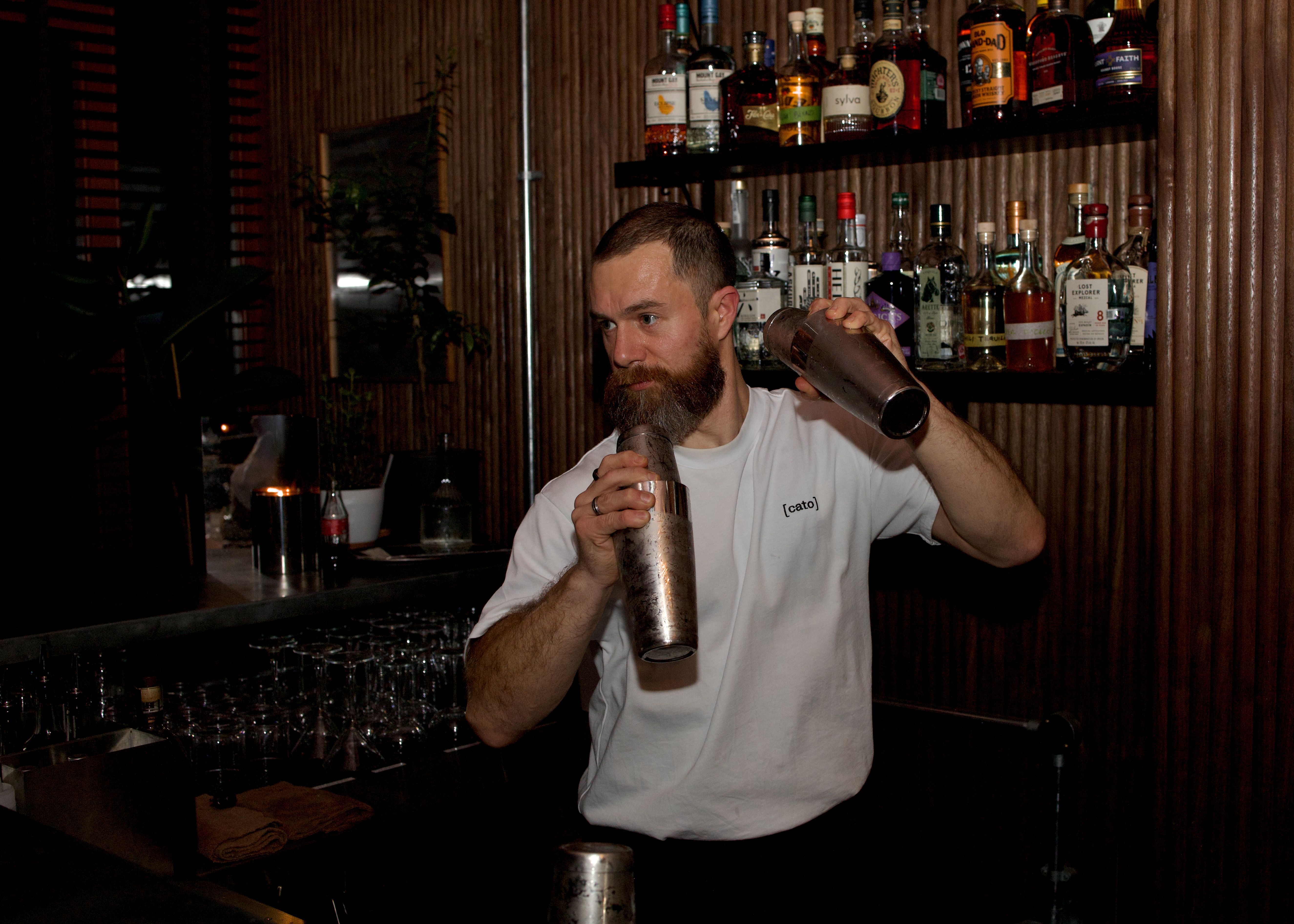 A bartender shaking two cocktails at the same time at The House of Julep in Covent Garden